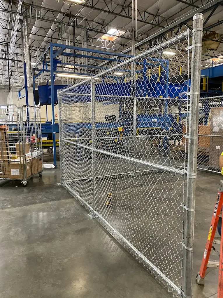Chain-link enclosure installed inside a warehouse.